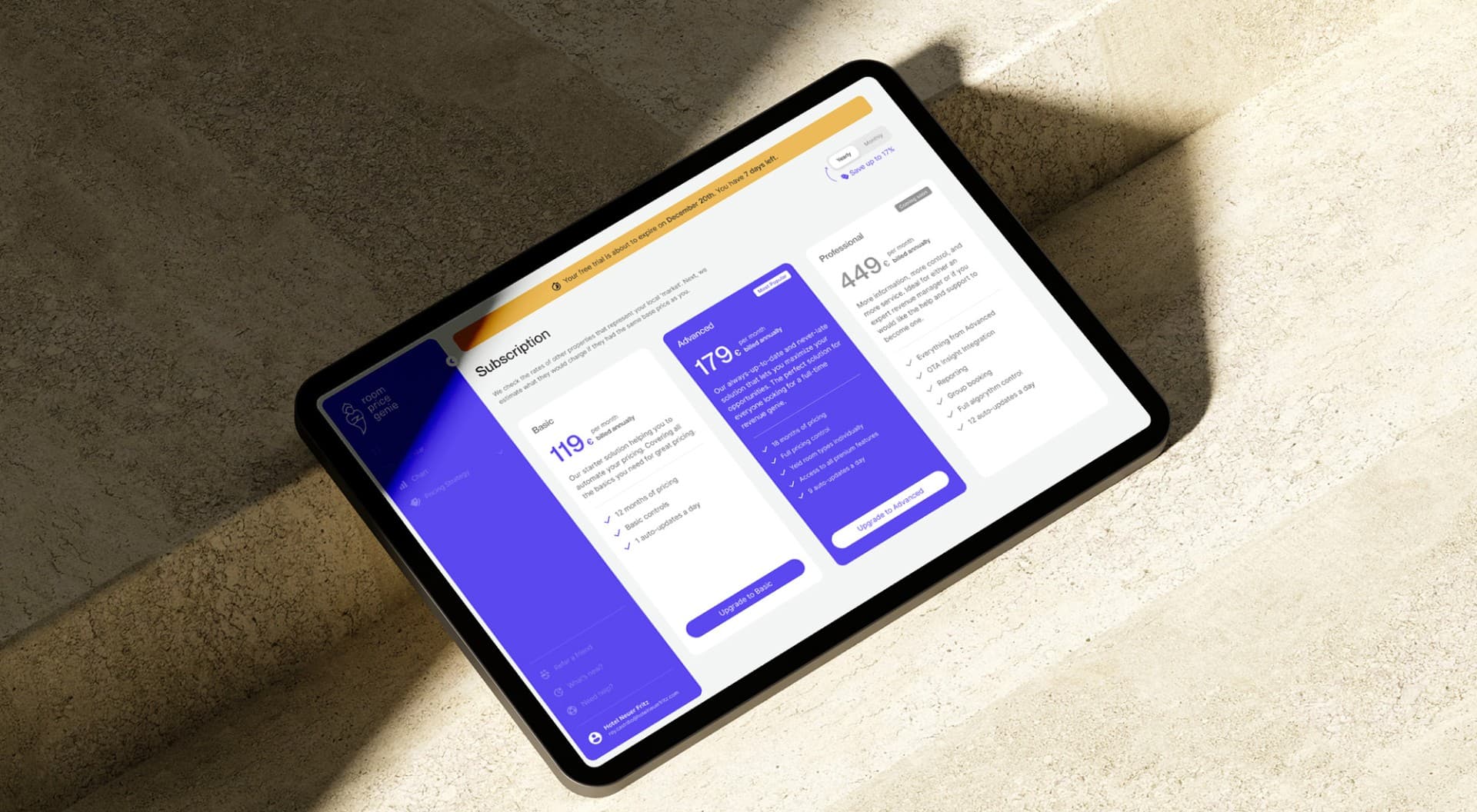 Tablet displaying a pricing overview and subscription models on a light stone surface, presenting different pricing options.