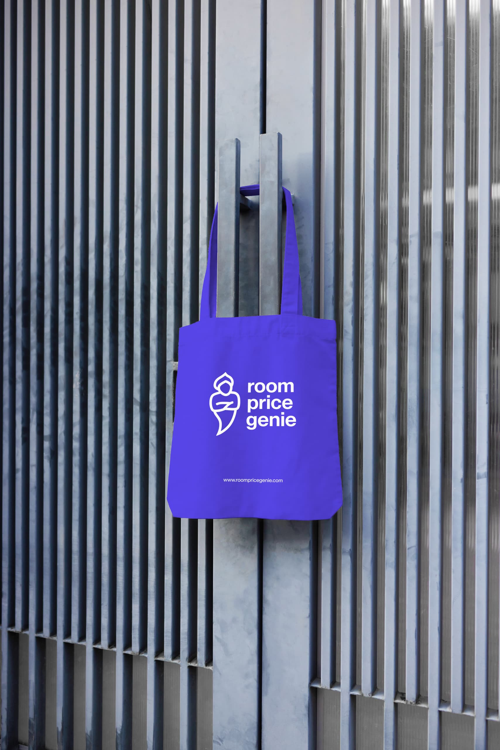 Blue Tote bag with room price genie logo in front of metal door